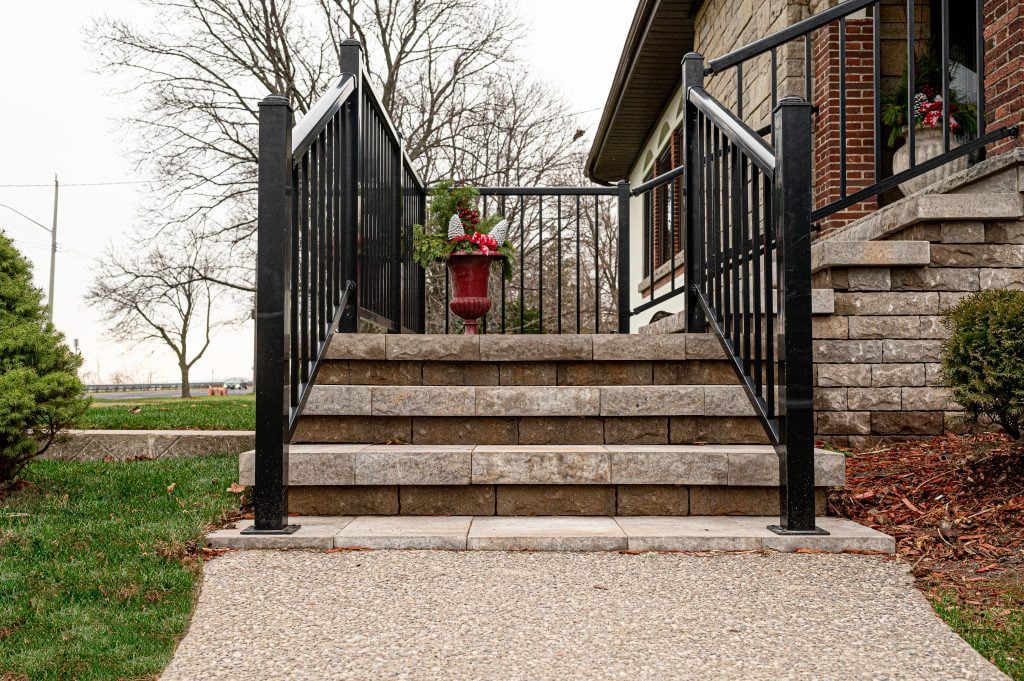 Front yard landscaping project showing stone steps with railing.