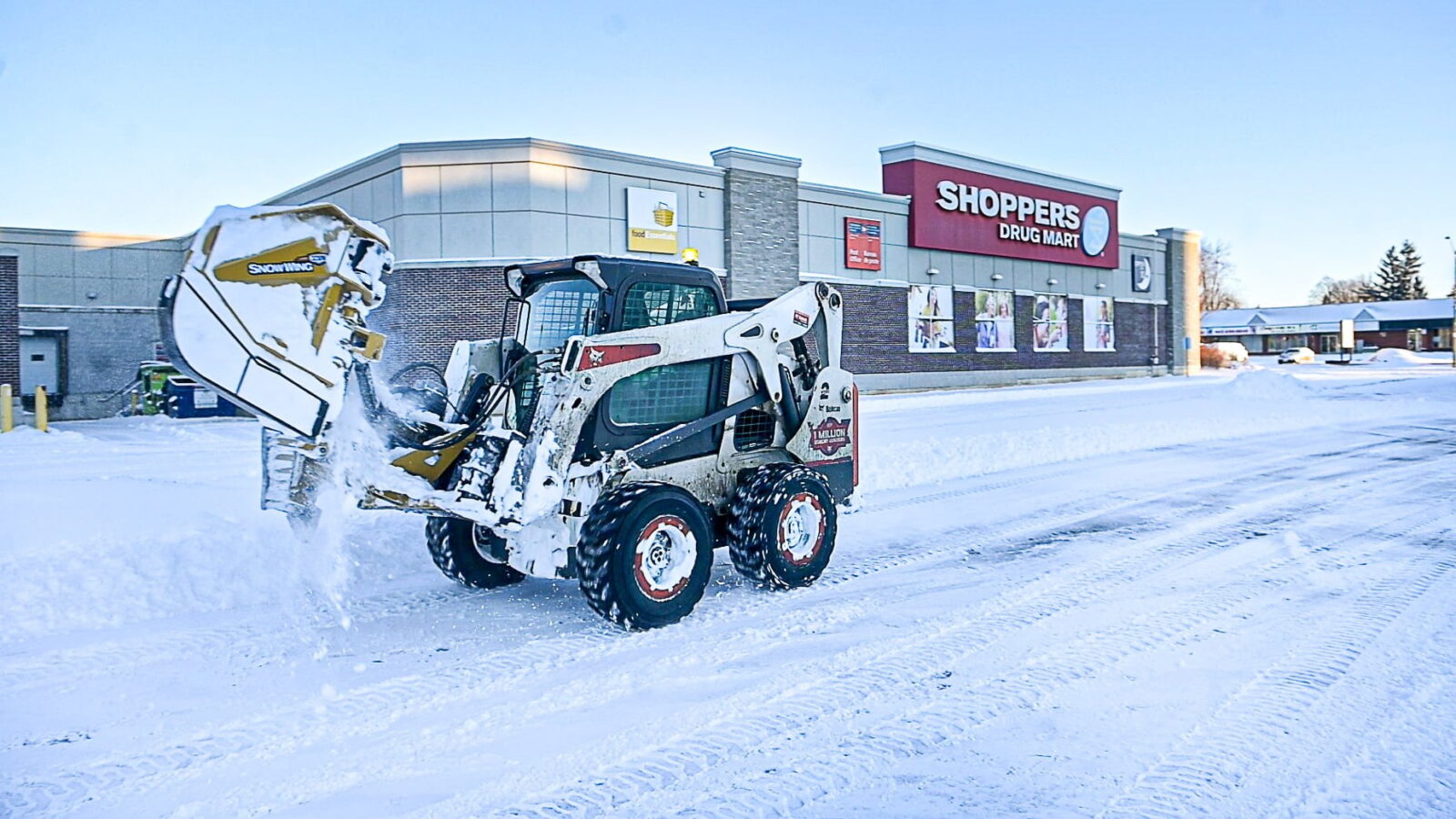 Creative Concepts Commercial snow removal services, skid steer clearing snow.