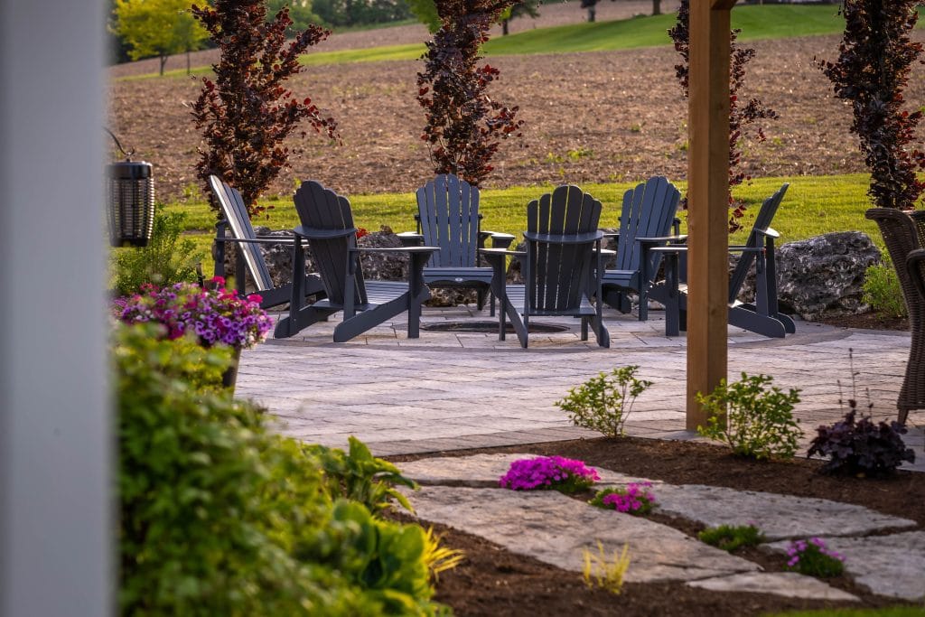 Stone fire pit area in a Flamborough backyard landscape project