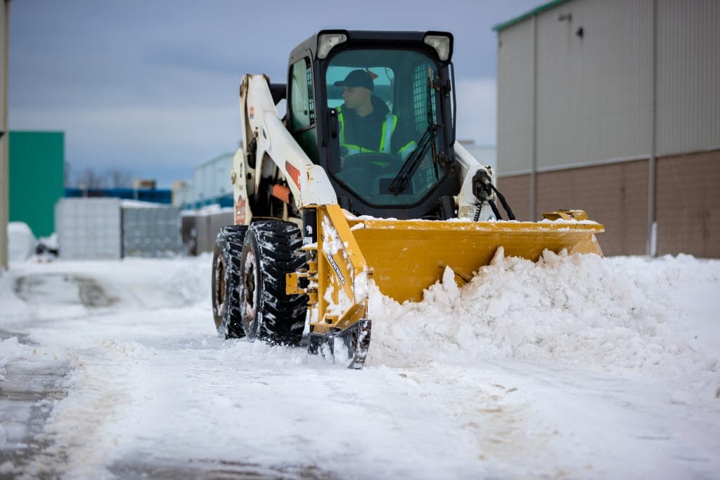 Creative Concepts Commercial snow removal services, skid steer clearing snow.