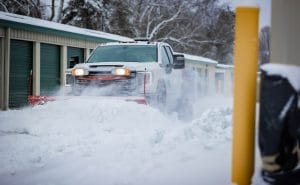 Creative Concepts Commercial snow removal services, truck with a plow clearing snow.