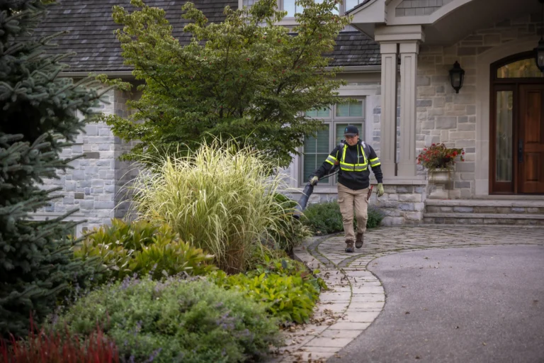Creative Concepts Landscapes Employee blowing leaves off a property in Oakville ontario