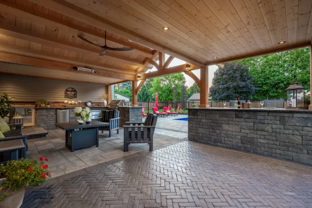 Outdoor kitchen and timber structure with stone patio in Oakville
