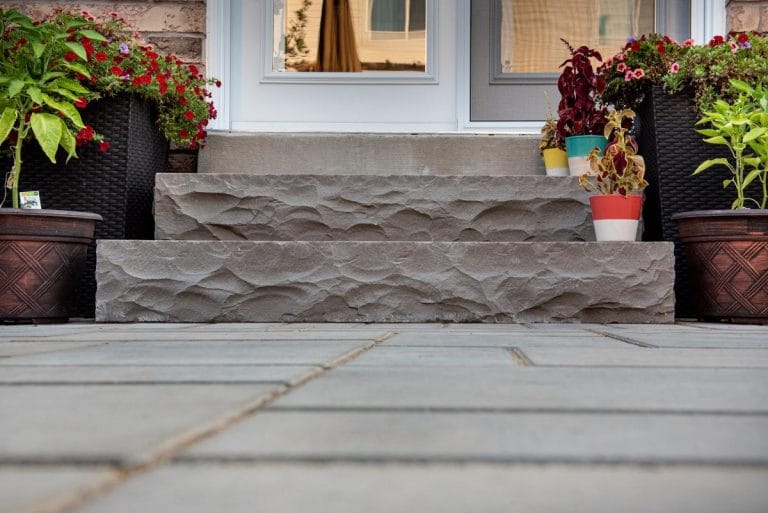Small backyard landscaping ideas from Creative Concepts showing interlocking stone and natural stone steps from a patio.