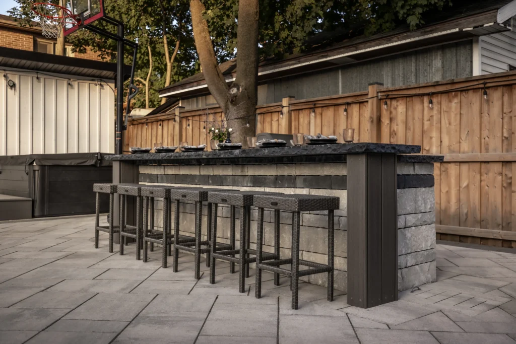 Outdoor kitchen zone with patio seating and poolside landscaping
