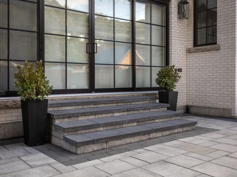 Small backyard landscaping ideas from Creative Concepts showing interlocking stone and natural stone steps from a patio.